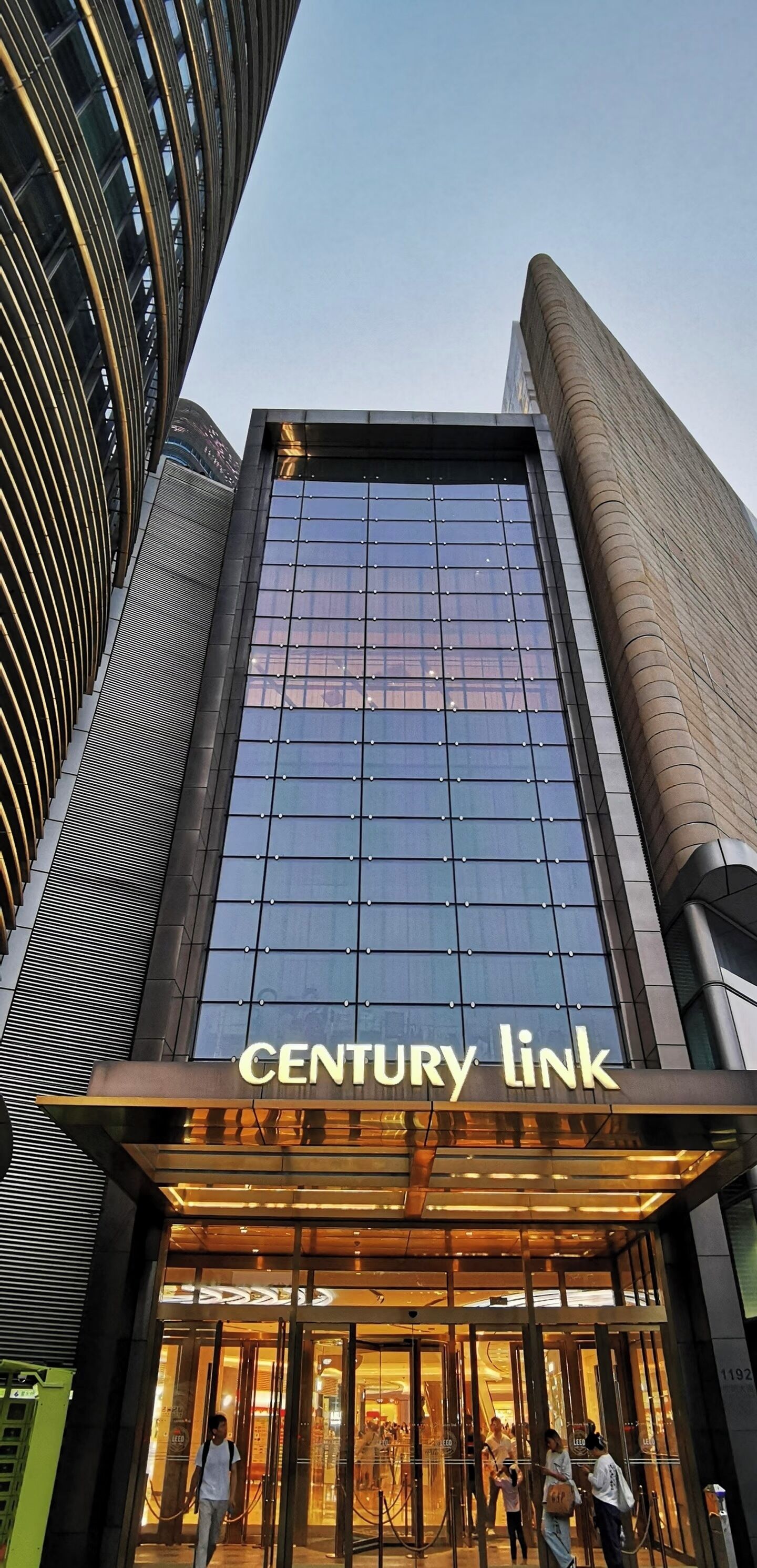 Un bâtiment moderne avec une façade en verre et l’inscription « CENTURY LINK » au-dessus de l’entrée.