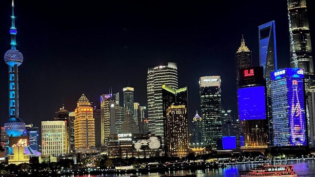 A city skyline at night with illuminated buildings and a river in the foreground. - JL Hotel Shanghai LujiazuiOriental Pearl (Shanghai)