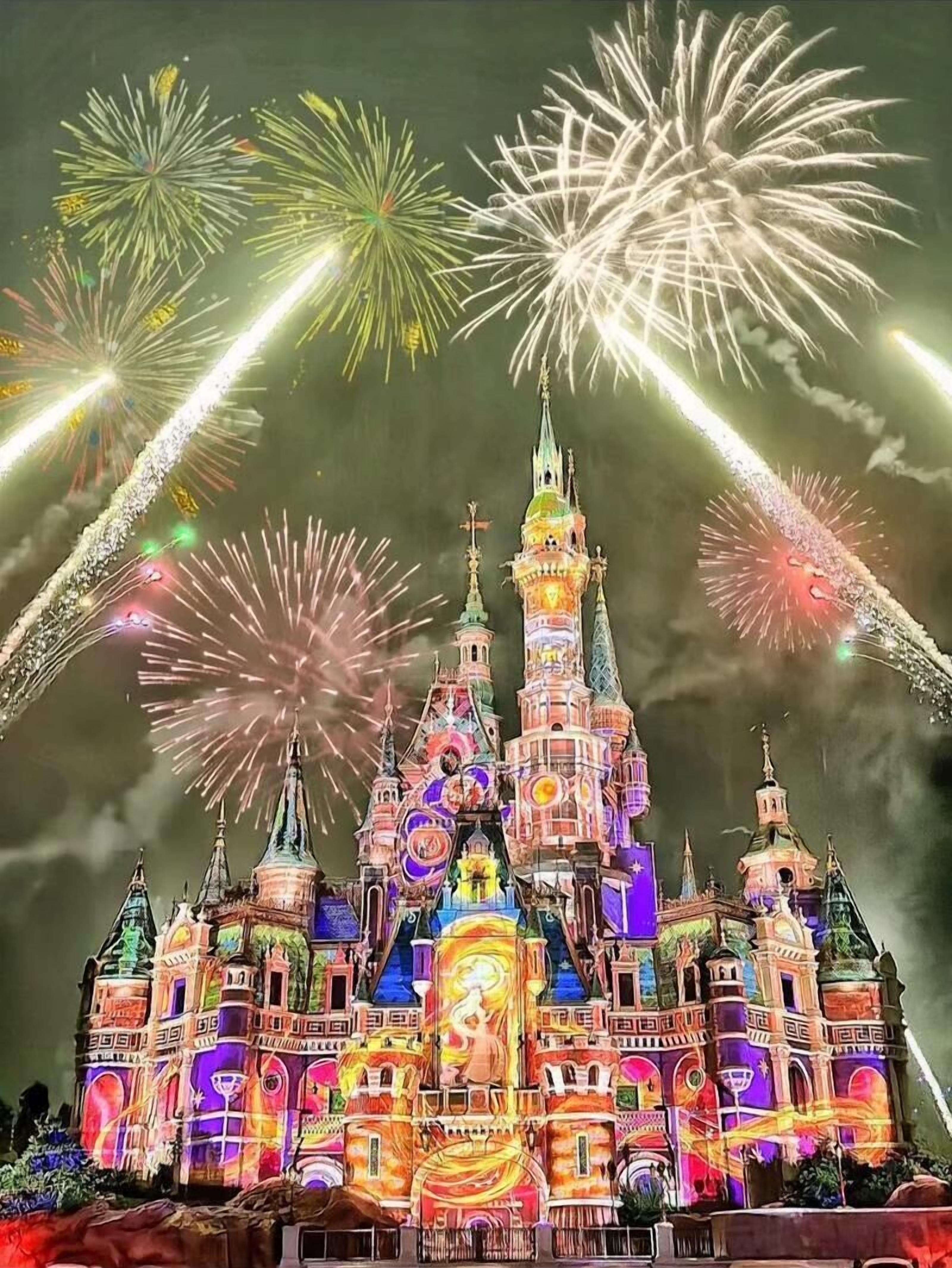 A castle-like structure with multiple spires and a central tower, illuminated by colorful lights.