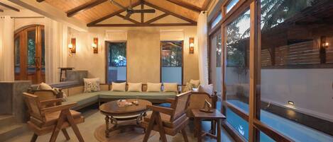 A spacious living area with a wooden ceiling, a large sofa set, and a coffee table.
