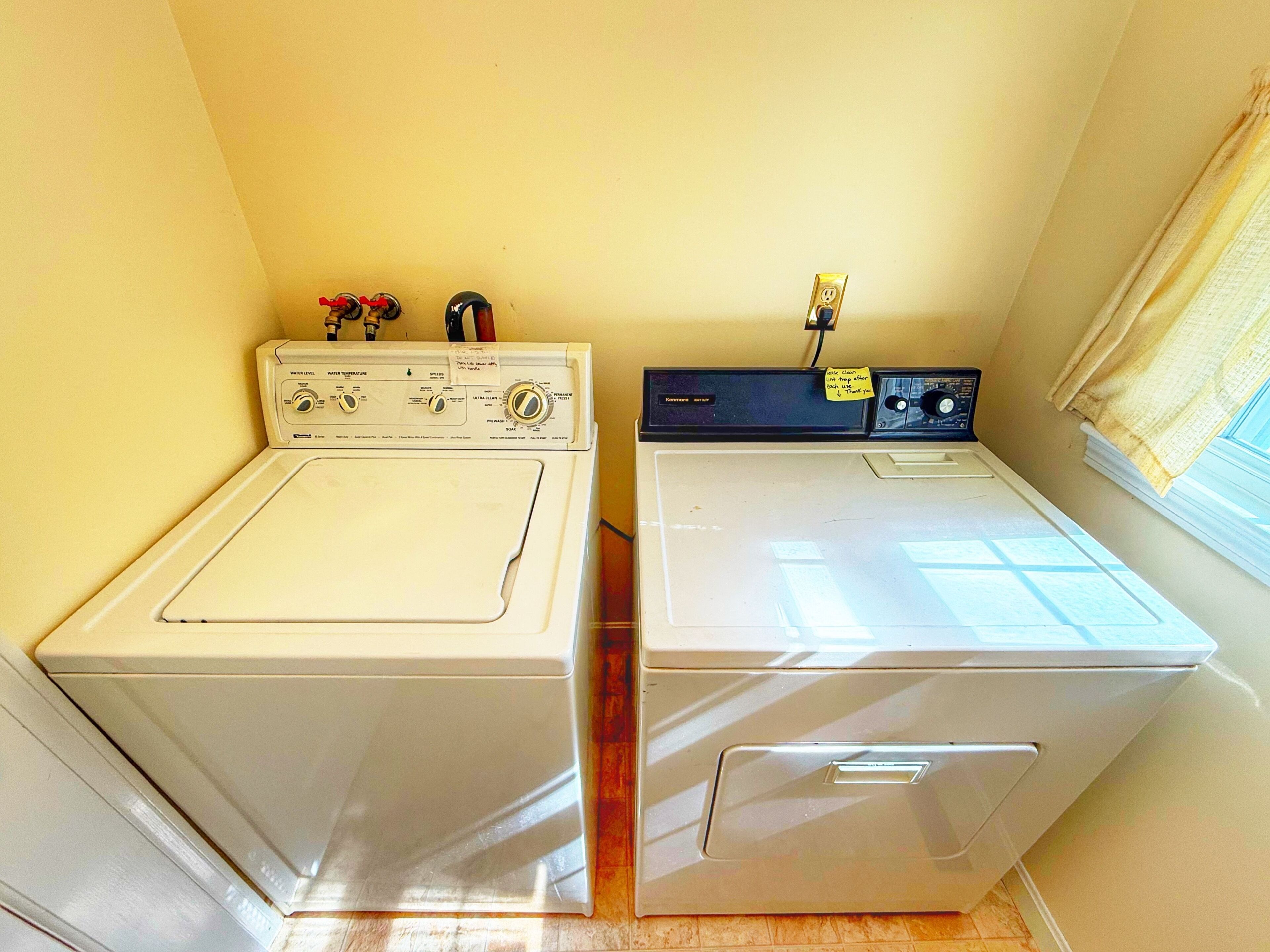A laundry area with two white front-loading washing machines.