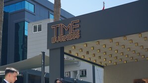 Un edificio moderno con un cartello che riporta la scritta 'TIME BUSINESS'.