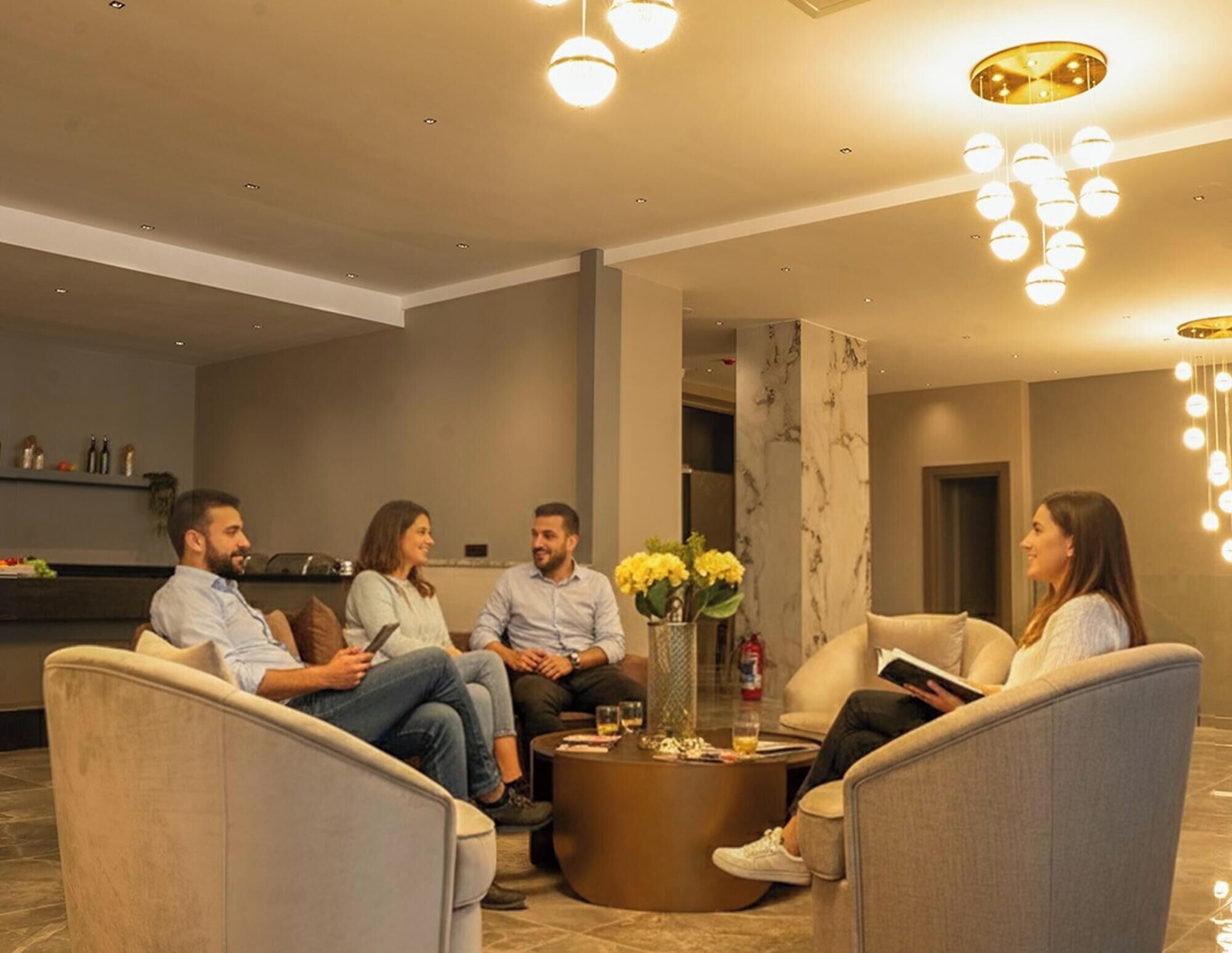 A modern lounge area with seating and a coffee table, featuring a marble column and ambient lighting.