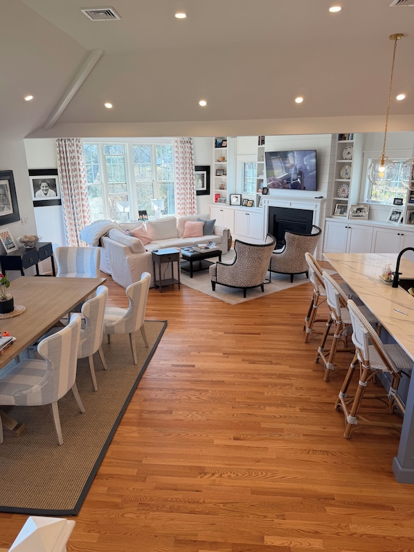 A spacious living area with a sofa, coffee table, and dining table.