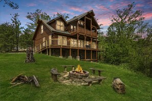 A two-story log cabin with a balcony, a fire pit, and picnic tables. - A View To A Dream -Scenic Views/ Hot Tub + Near Dollywood (Sevierville)
