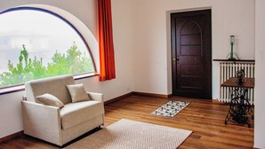 A room with a large window, a sofa, a radiator, and a sewing machine. - Paradise B&B. Your Exclusive Refuge in Castiglione del Lago! (Panicarola)
