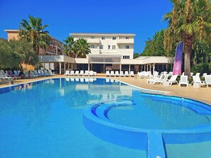 A swimming pool with lounge chairs and a building in the background. - FRUIT VILLAGE DIAMANTE Dominicus (Grisolia)