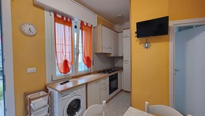 Una cucina funzionale con lavatrice, fornello e lavandino.