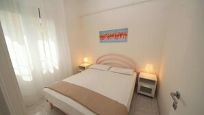 Una camera da letto ordinata con un letto, comodini e un quadro appeso al muro.