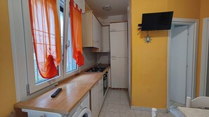 Una cucina compatta con fornelli, lavello e lavatrice.