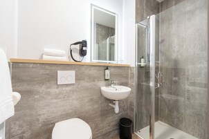 Un baño moderno con ducha, inodoro y lavamanos.