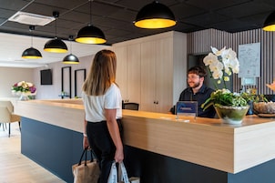 Una mesa de recepción con mostrador de madera, iluminación colgante negra y un mapa colgado en la pared.