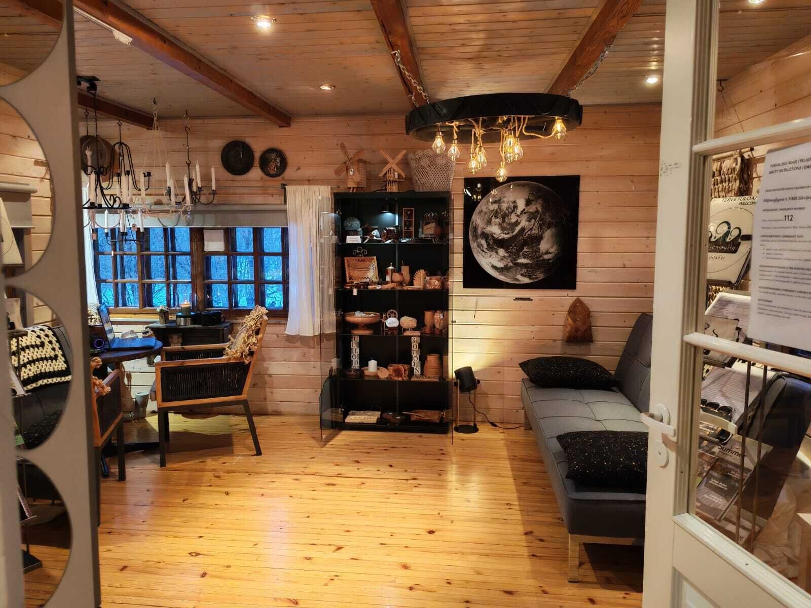 A cozy wooden interior with a dining area, a bookshelf, and a sofa.