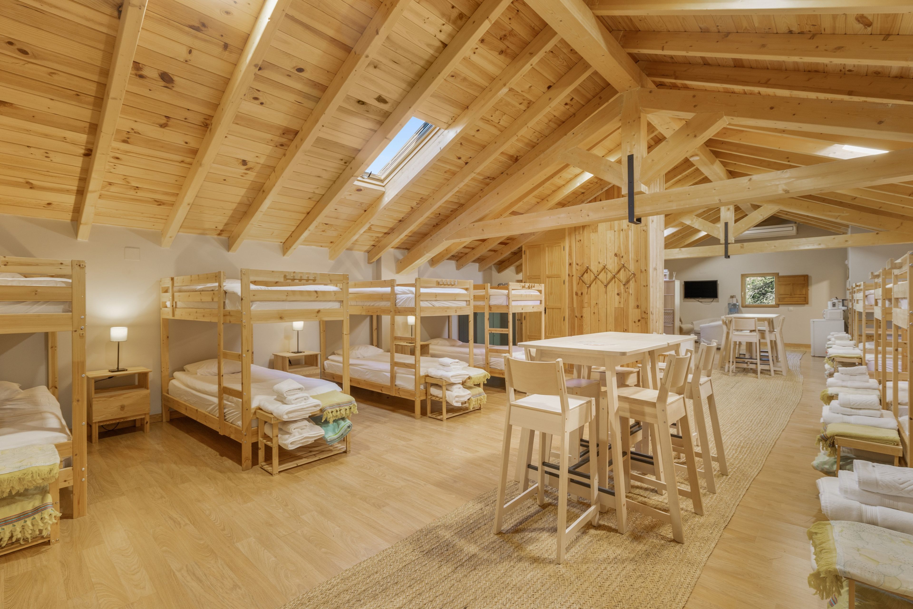 Un interior de madera con literas, una mesa de comedor y sillas.