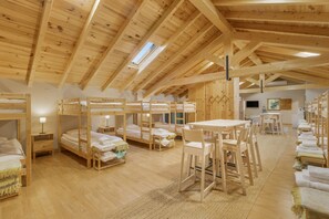 A wooden interior with bunk beds, a dining table, and chairs. - The Rural Hostel in Mombeltrán, Ávila, Tiétar Valley (Mombeltrán)