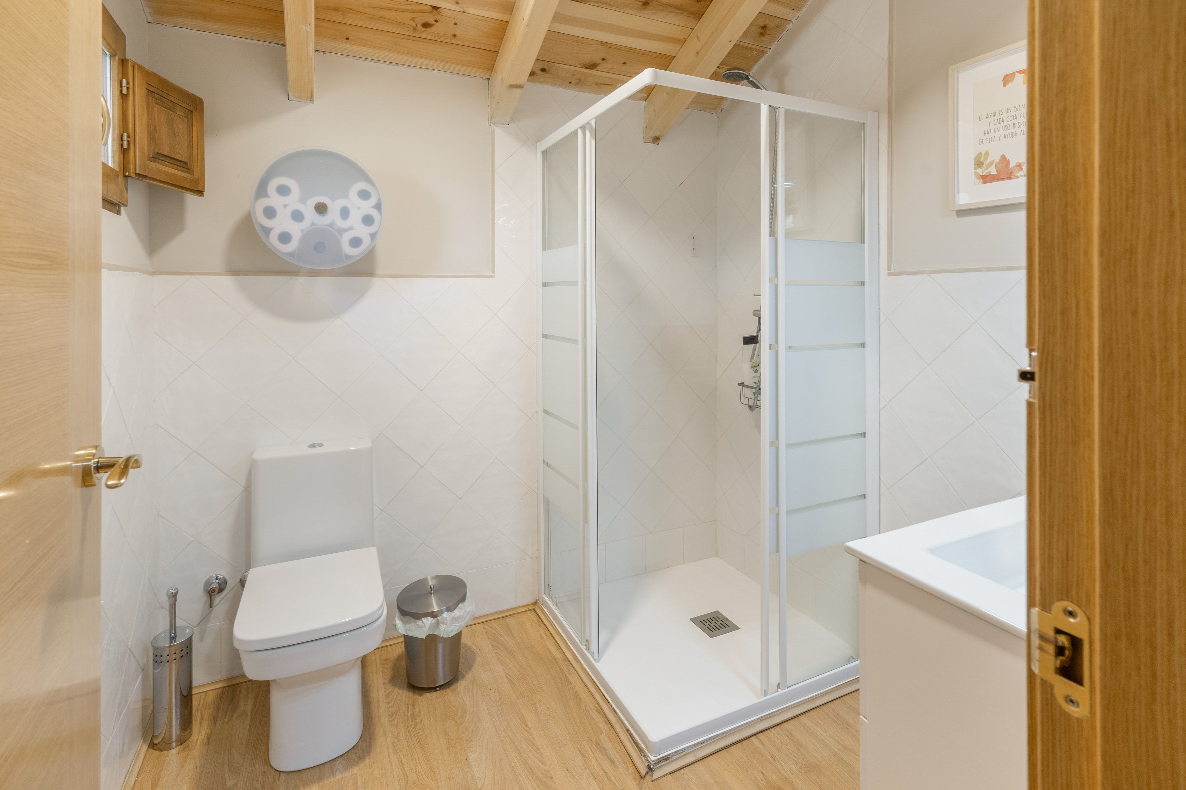 Un baño moderno con inodoro, cabina de ducha y lavabo.