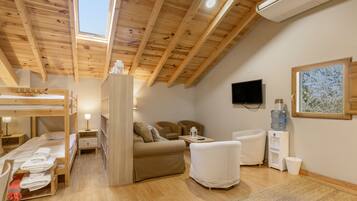 Una habitación acogedora con una cama litera, un sofá, un televisor y un dispensador de agua.