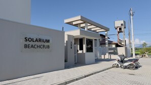Um edifício moderno com uma placa que diz 'SOLARIUM BEACH CLUB'.