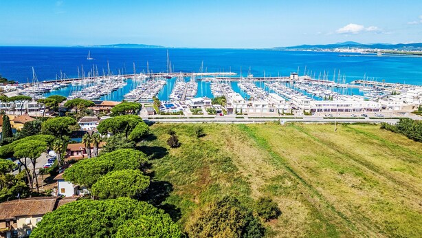 A marina with numerous boats docked, surrounded by greenery and buildings. - Atelier Vella by Interhome (Scarlino)