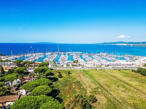 A marina with numerous boats docked, surrounded by greenery and buildings. - Atelier Vella by Interhome (Scarlino)
