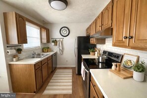 A kitchen with wooden cabinets, a stainless steel refrigerator, a stove, and a sink. - Spacious 6bed Woodland Retreat With Movie Room Deck (California)