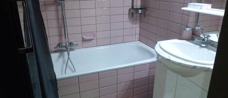 A bathroom with a bathtub, a sink, and a shower.
