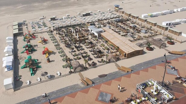 An aerial view of a beachside resort with multiple buildings, a pier, and a sandy beach. - Zeezicht Studio Alisa (Blankenberge)