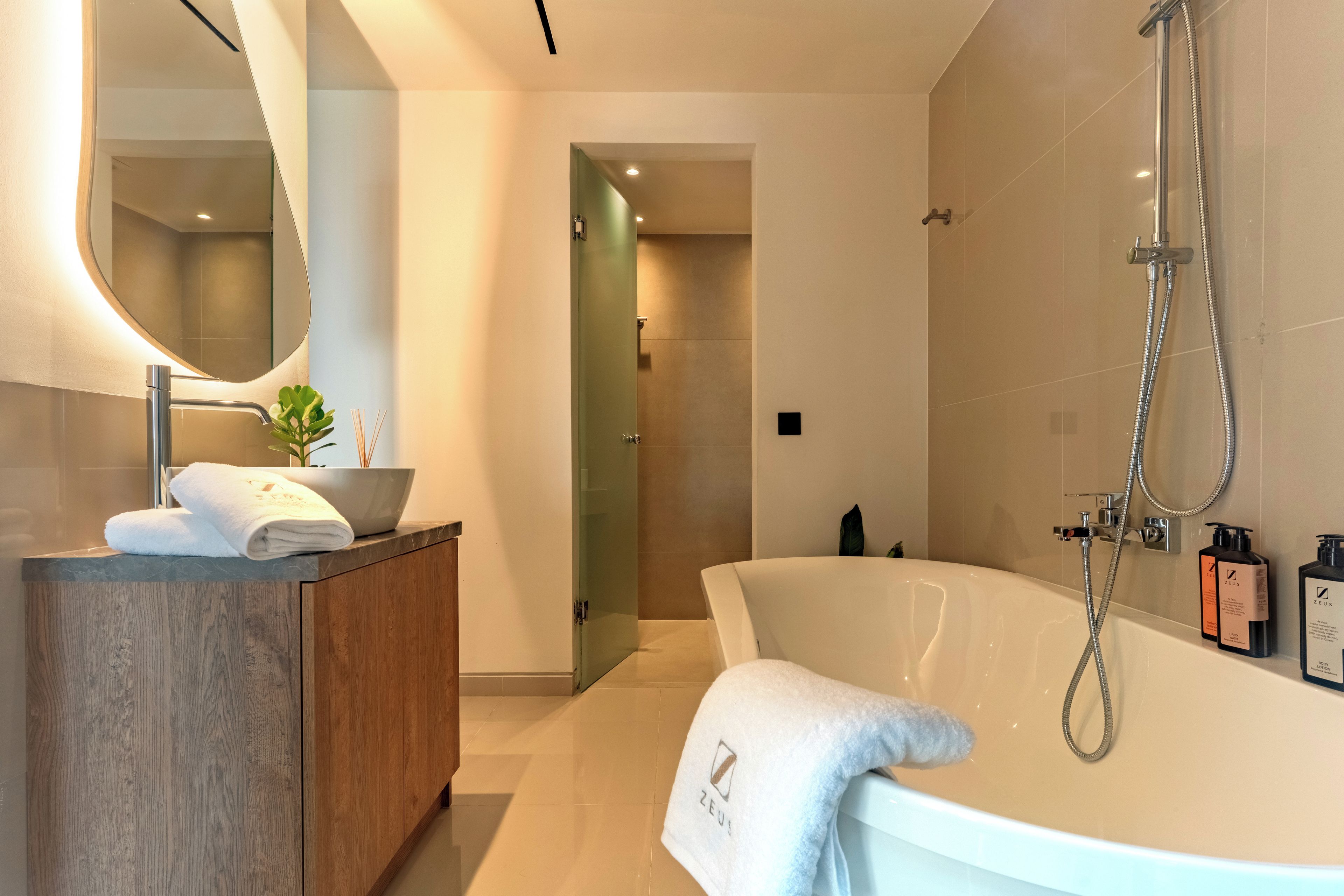 A modern bathroom with a freestanding bathtub, a vanity with a mirror, and a shower area.