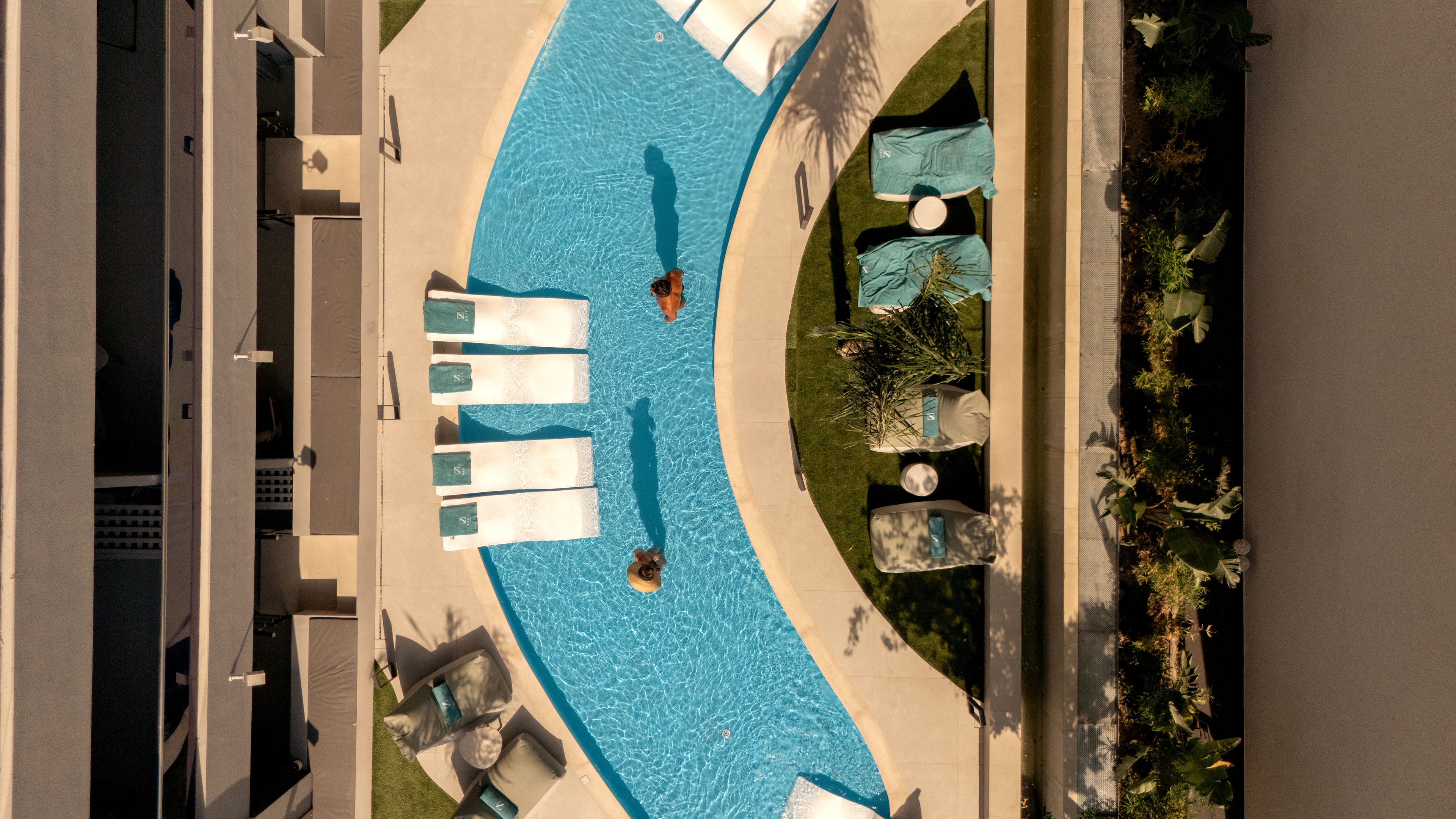 A swimming pool with lounge chairs and a pathway.