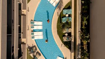 A swimming pool with lounge chairs and a pathway.