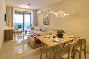 Una sala moderna con comedor, un sofá, una mesa de centro y vistas al exterior.