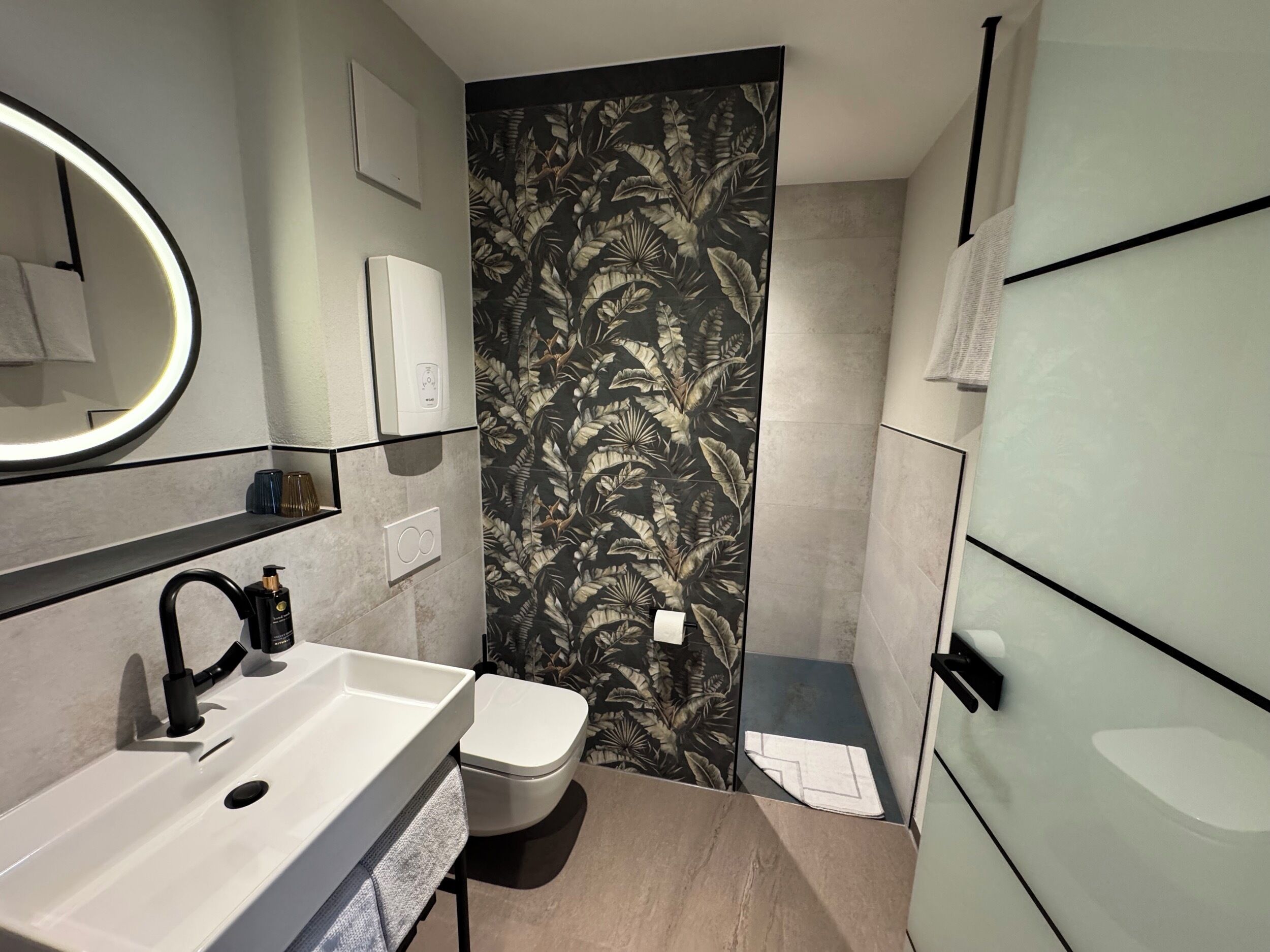 A modern bathroom with a sink, toilet, and towel rack.