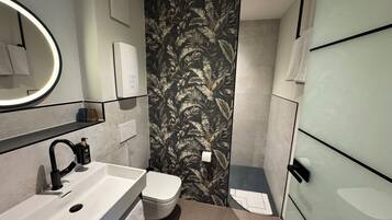 Ein modernes Badezimmer mit Waschbecken, Toilette und Handtuchhalter.