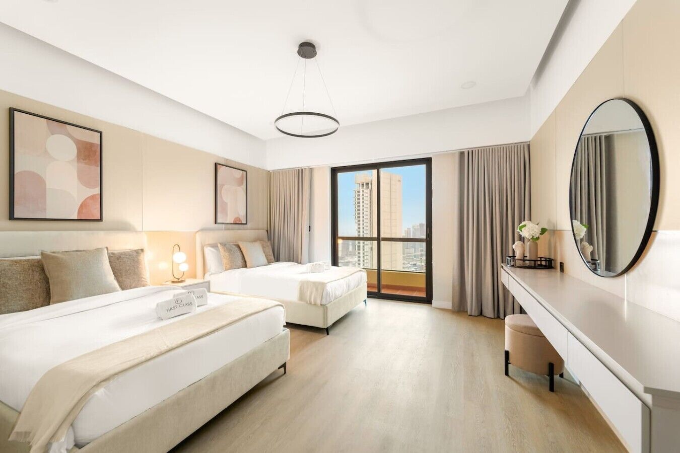 A modern hotel room with two beds, a large mirror, a desk, and a city view.