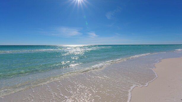 A beach with clear blue water and a bright sun. - Retreat at 30A (Santa Rosa Beach)