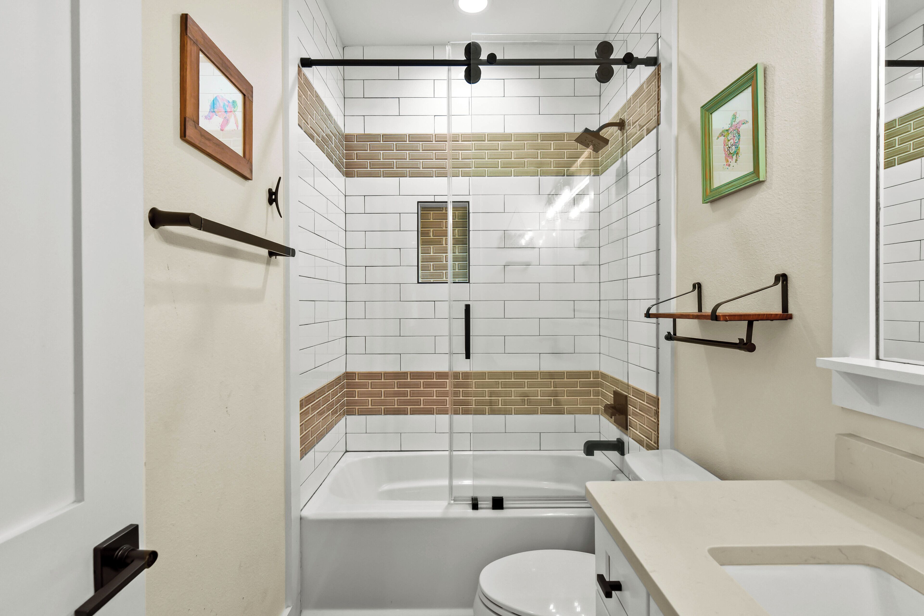 A bathroom with a bathtub, toilet, and a shower area.