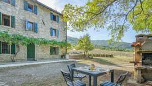 A stone building with a patio area featuring a table and chairs. - Beautiful private villa for 12 guests with private pool, WIFI, TV and pets allowed (Castel Di Casio)