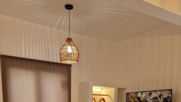 A modern bedroom with a bed, a hanging light fixture, a TV, and a wardrobe. - Alya Paros – Calm Cycladic Aesthetic (Paroikia)