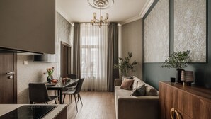 A modern kitchen with a dining area, a sofa, and a cabinet. - White Lotus by Fragola Apartments (Kraków)