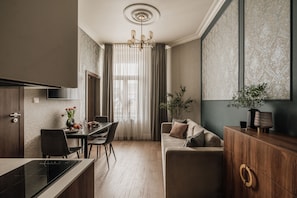 A modern kitchen with a dining area, a sofa, and a cabinet. - White Lotus by Fragola Apartments (Kraków)