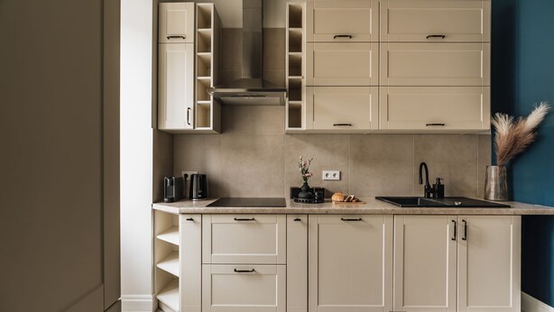 A modern kitchen with built-in cabinets, a stove, and a sink. - White Lotus by Fragola Apartments (Kraków)