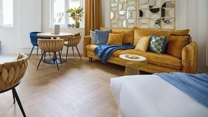 Une chambre d’hôtel moderne avec un canapé, une table à manger et des chaises.