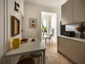 Eine moderne Küche mit weißem Tisch, einer Mikrowelle und einem Schrank.