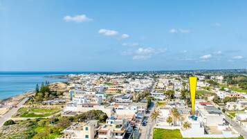 Un pueblo costero con una mezcla de edificios residenciales, un marcador amarillo destacado y vistas al mar.