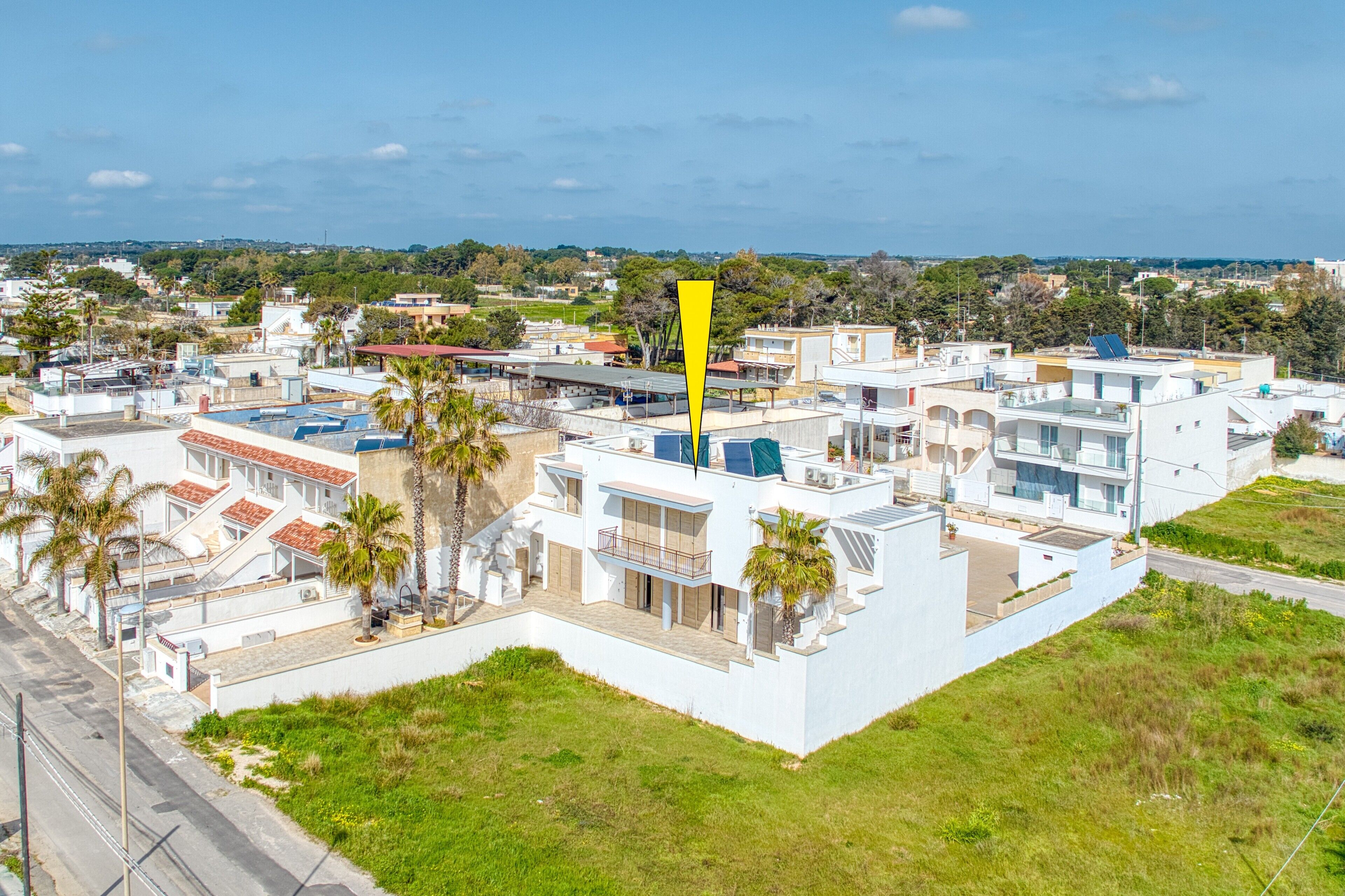 Un immeuble résidentiel moderne, doté de plusieurs étages, de balcons et de panneaux solaires.