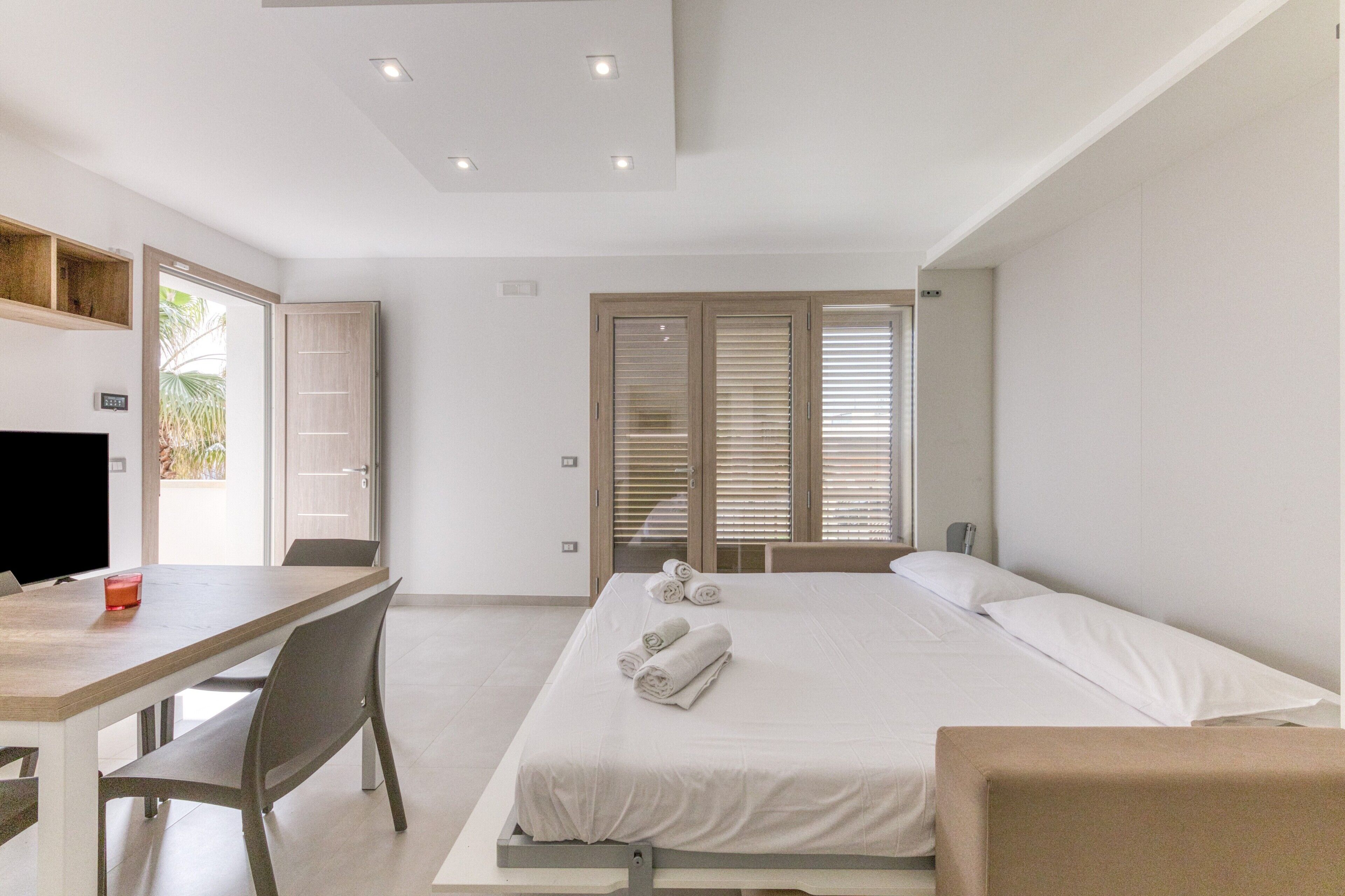 Une chambre à coucher avec un lit, un bureau et une télévision.
