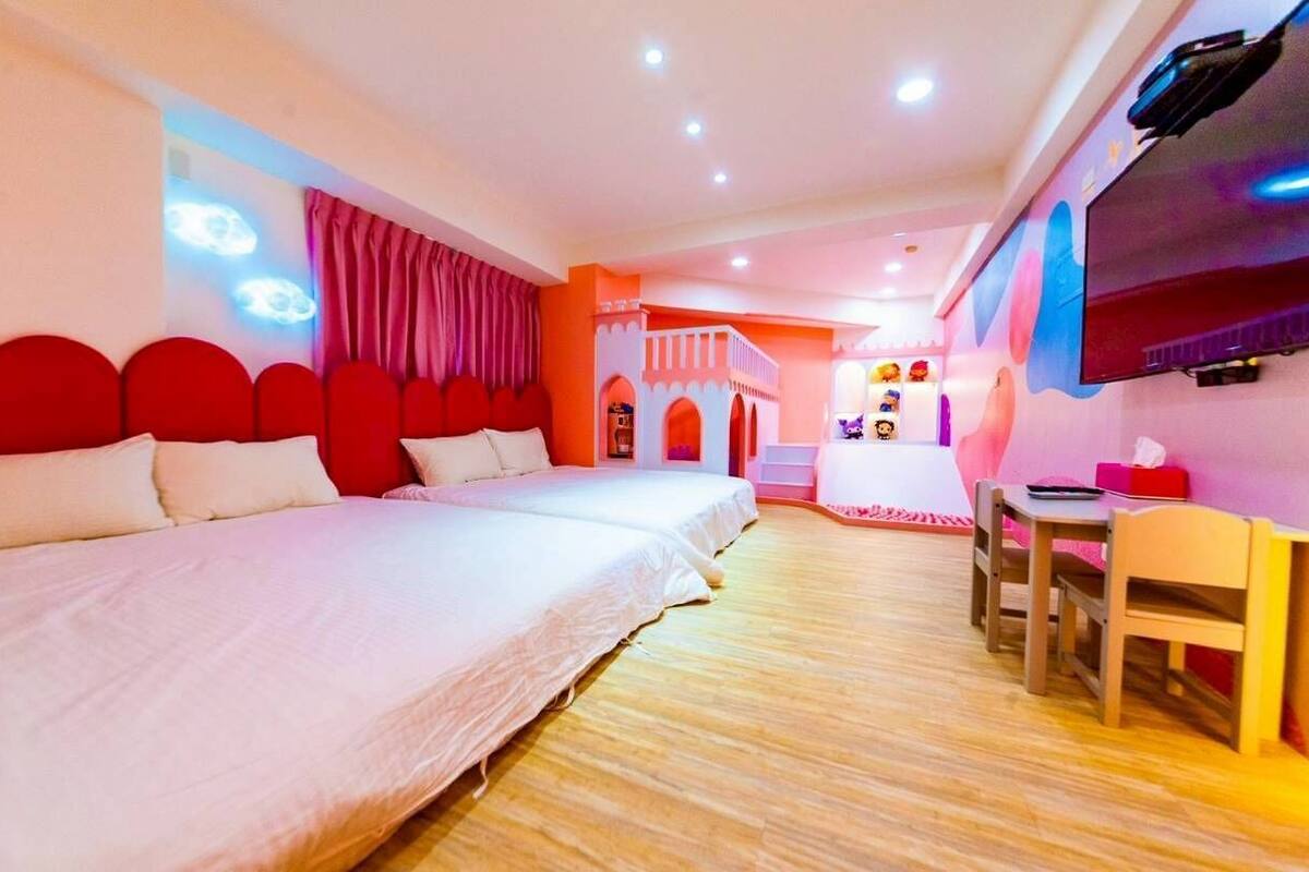 Una habitación de hotel con una cama grande, un escritorio y un televisor.