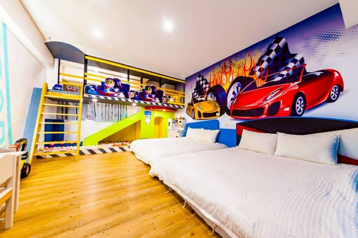 Un dormitorio con literas, un mural de coches de carreras y suelo de madera.