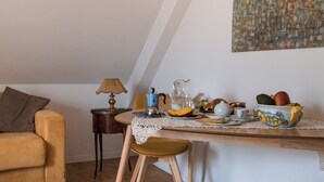 Un coin repas avec une table mise pour le petit-déjeuner, une lampe et un tableau accroché au mur.