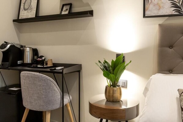 Ein modernes Zimmer mit Schreibtisch, Stuhl und Nachttisch mit Pflanze.